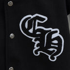 Black varsity jacket close-up with large embroidered emblem on front