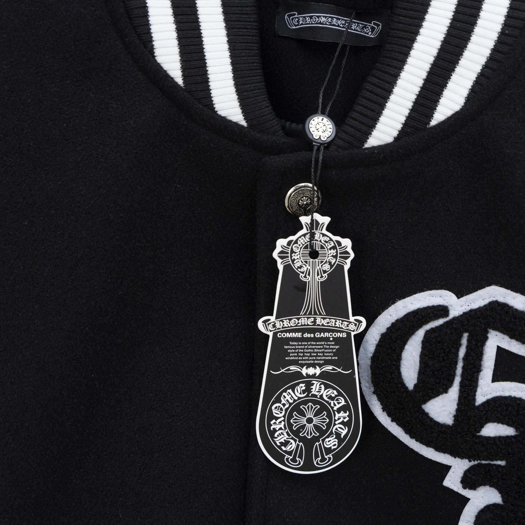 Black varsity jacket close-up with ribbed striped collar and snap button