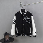 Black and white varsity jacket with snap buttons and ribbed striped cuffs