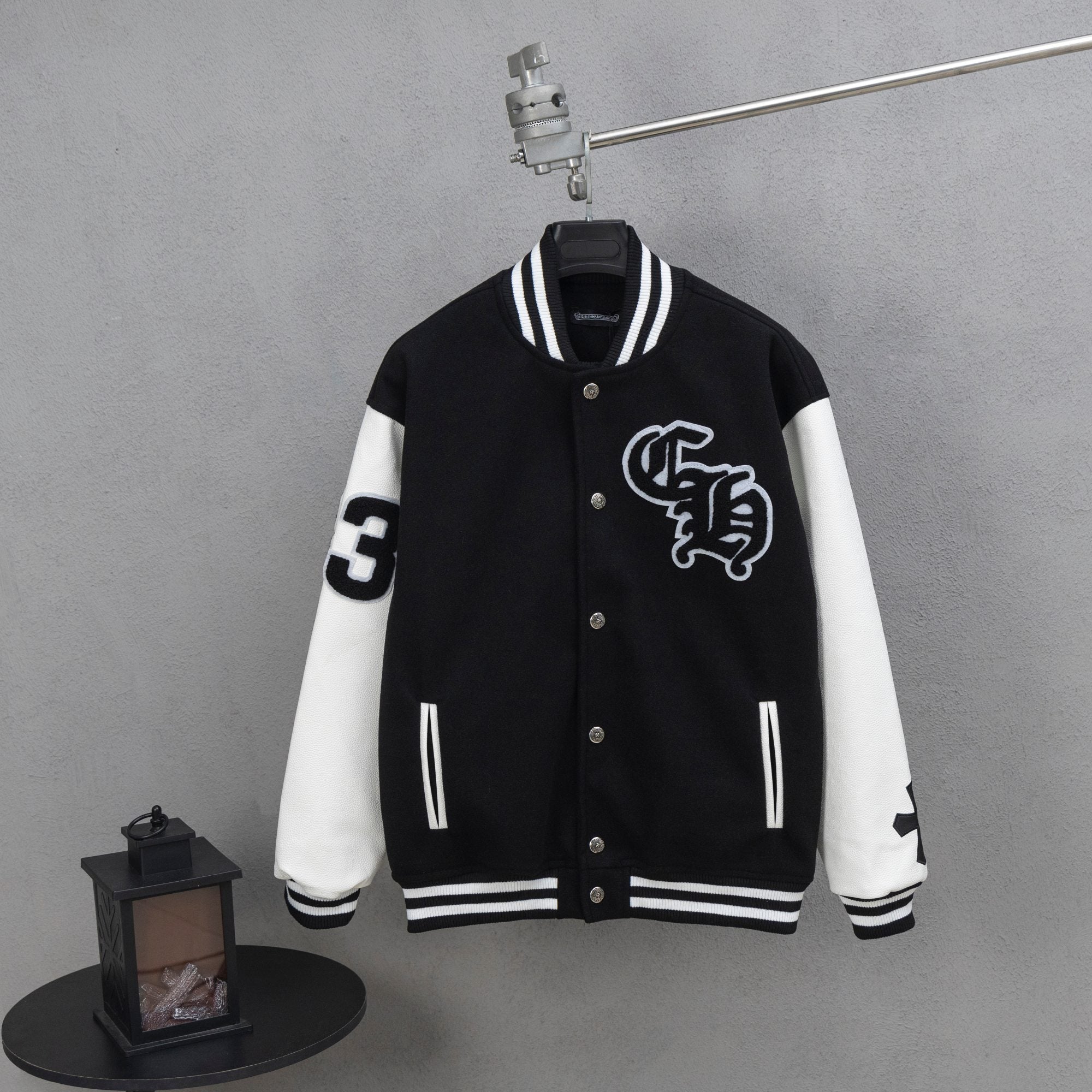 Black and white varsity jacket with snap buttons and ribbed striped cuffs