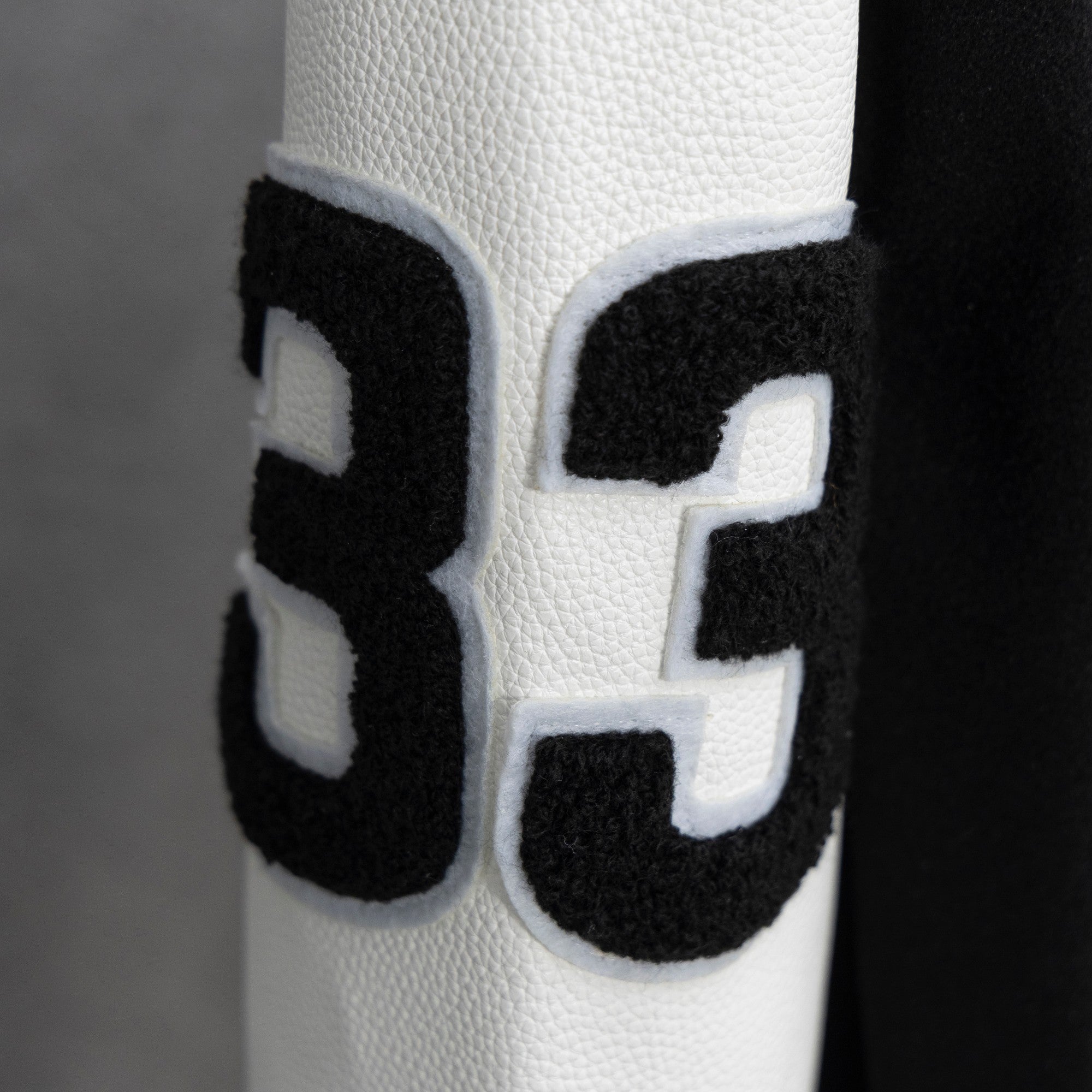 Black-and-white varsity jacket sleeve with large number 3 applique patch