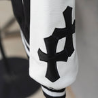 Black-and-white varsity jacket sleeve with cross-style applique detail