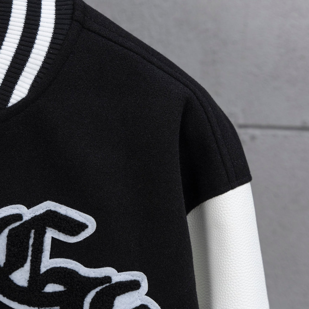 Black and white varsity jacket close-up with ribbed striped collar trim
