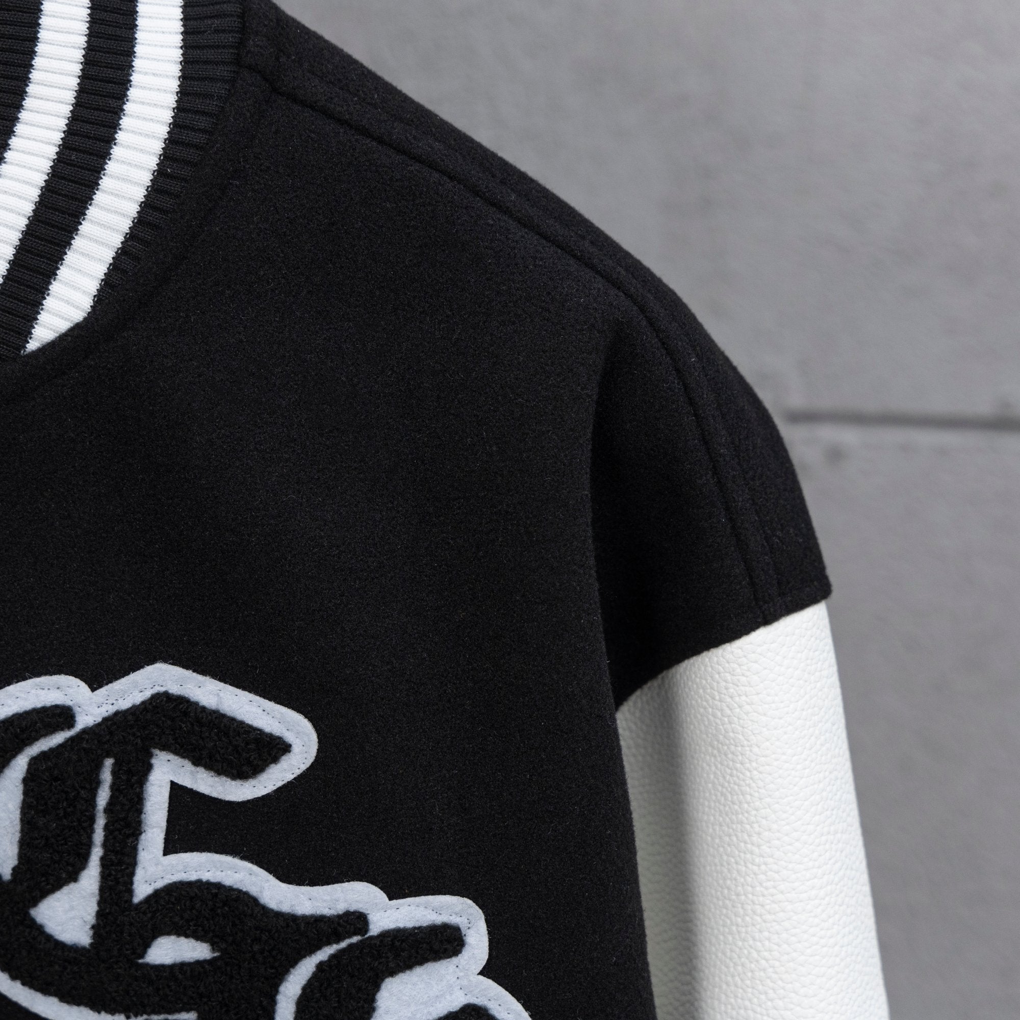Black and white varsity jacket close-up with ribbed striped collar trim