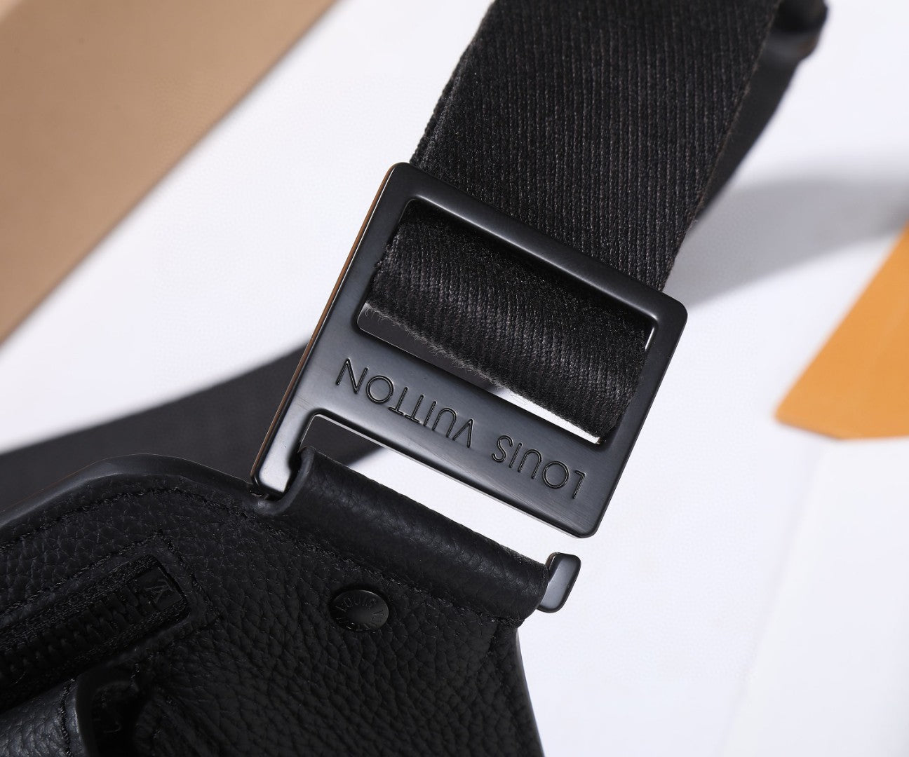 Black belt bag strap buckle with engraved “Louis Vuitton” on keeper