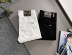 Black and white denim pants folded and displayed, with front pockets and logo patch