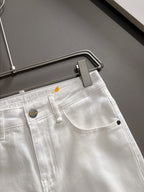 White denim pants close-up at waistband, button and belt loop detail