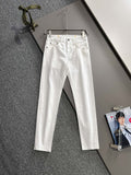 White denim pants hanging on a metal hanger, front view with belt loops