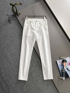 White denim pants hanging on a metal hanger, front view with belt loops