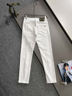 White denim pants hanging, front view with belt loops and button closure