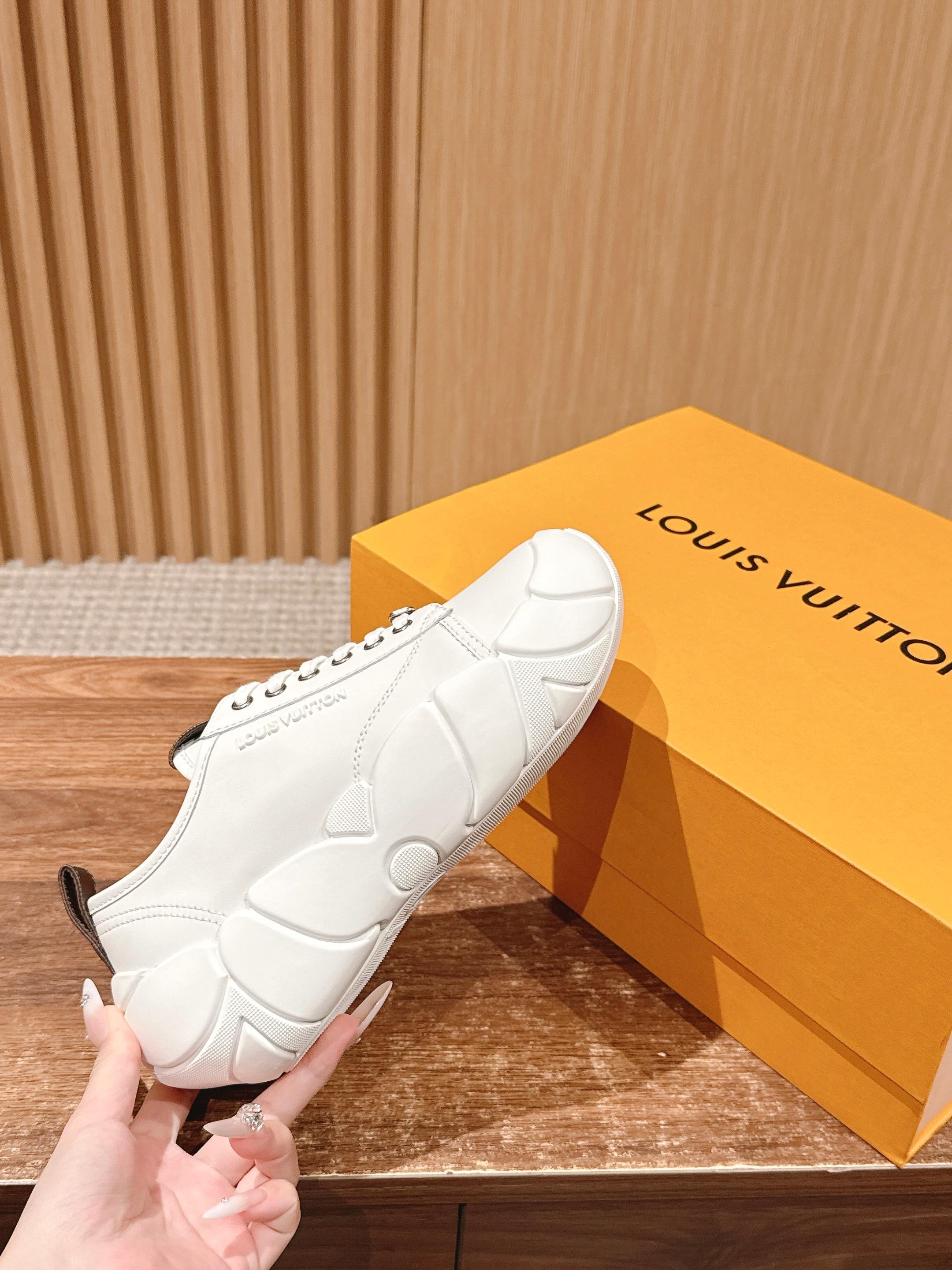 Louis Vuitton unisex sneaker held by hand, white leather with chunky molded sole