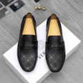 Black patterned leather loafers with strap and buckled ornament, flat slip-on design.