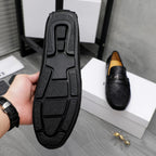 Black loafer outsole with raised tread pattern; slip-on shoe bottom view.