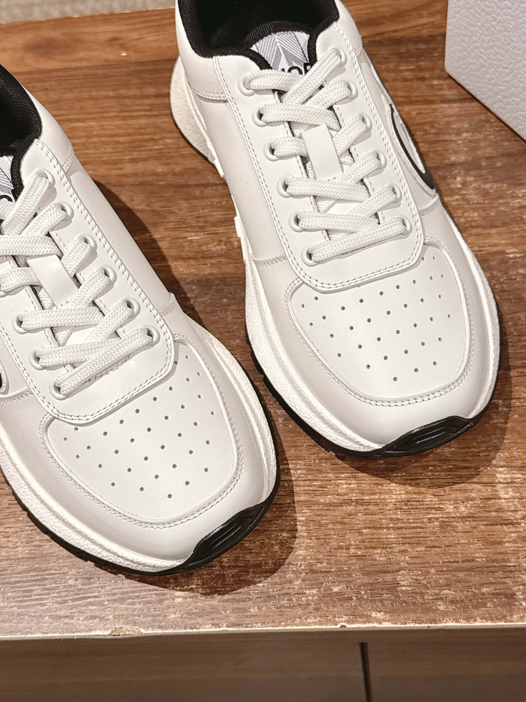 Dior unisex sneakers close-up, white leather with perforations and white laces