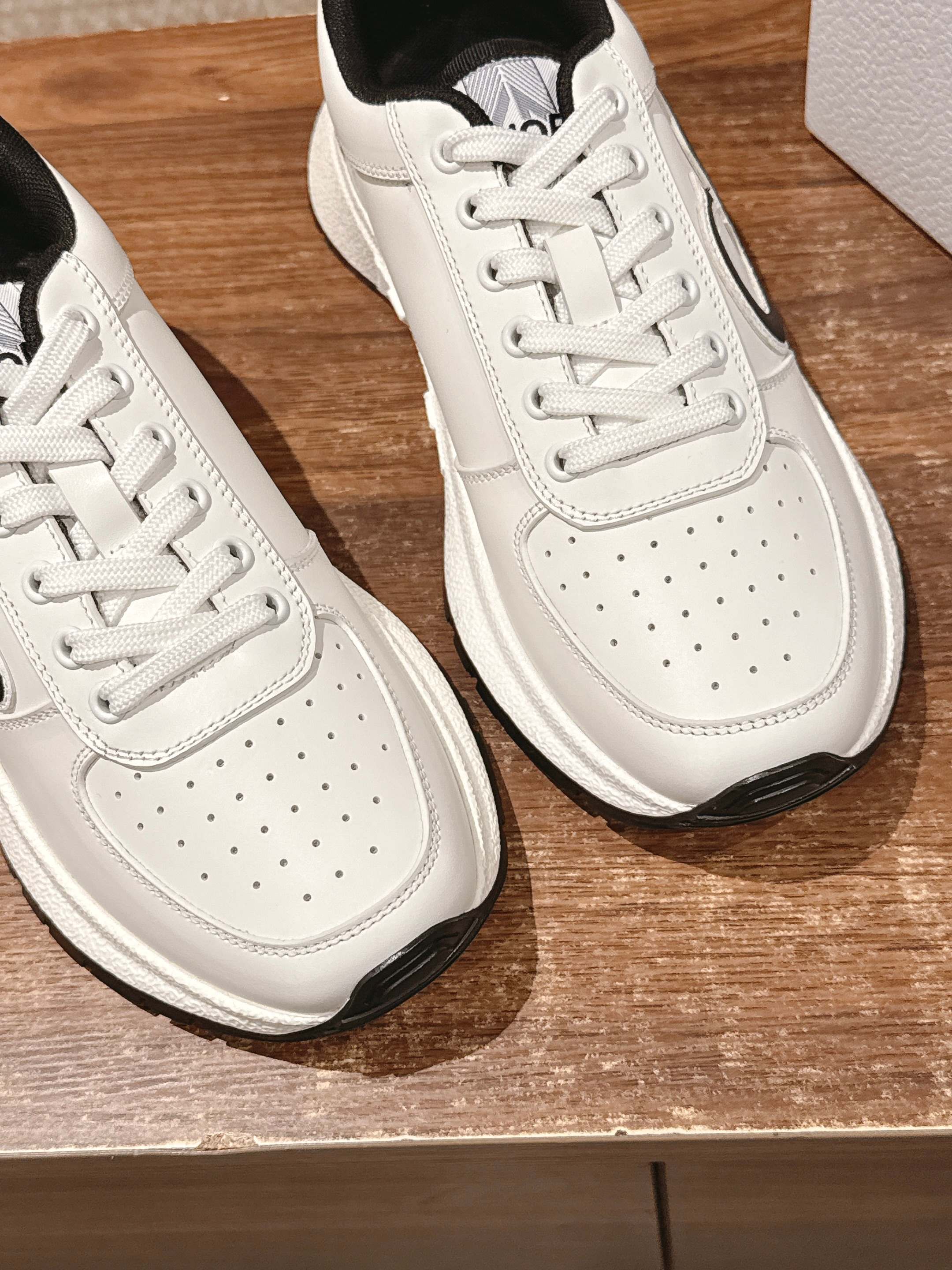 Dior unisex sneakers close-up, white leather with perforations and white laces