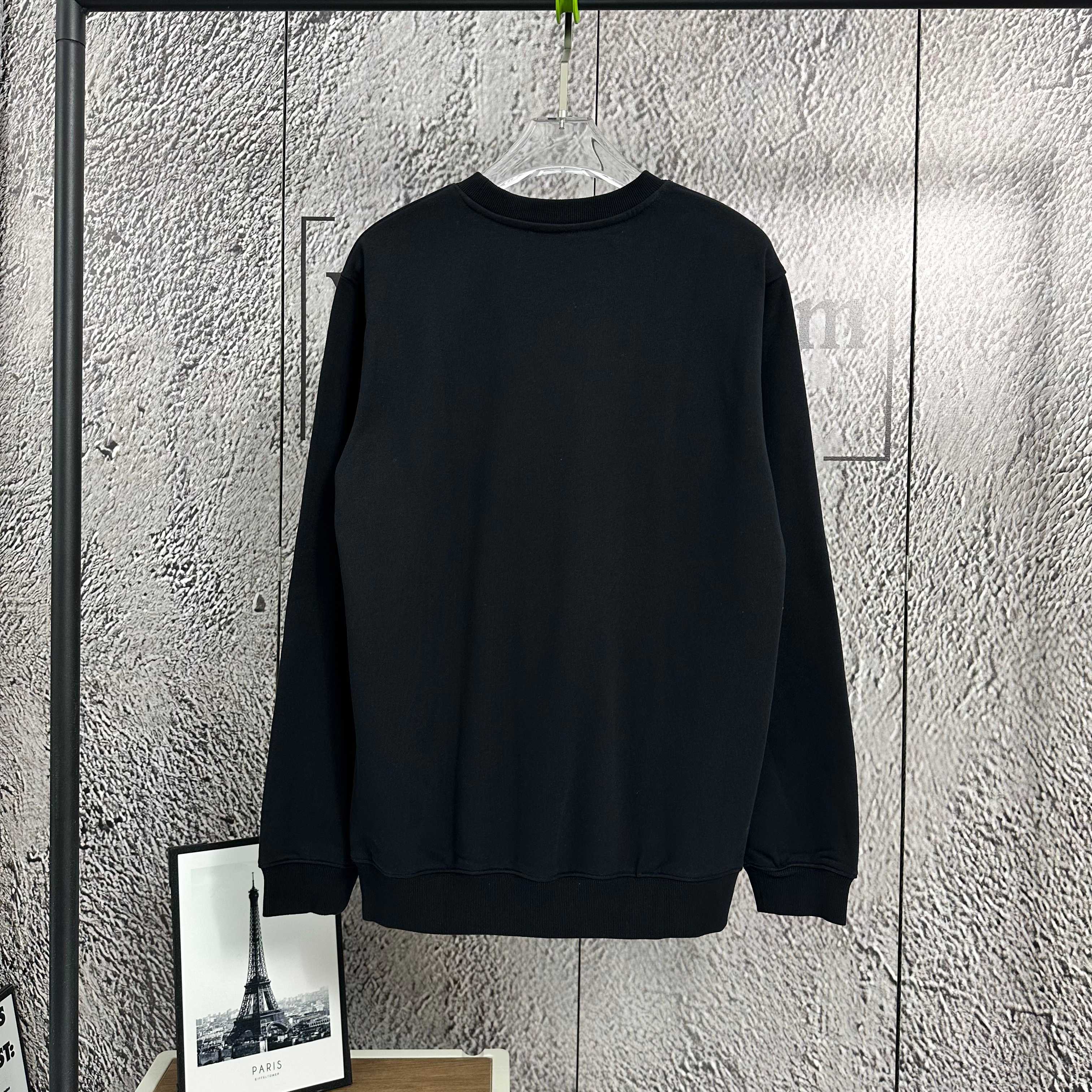 Black crewneck sweatshirt with ribbed cuffs and hem