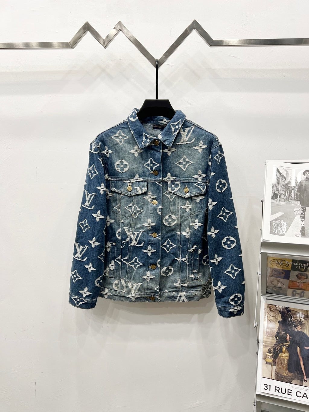 Blue denim jacket with white monogram pattern, button front and chest pockets