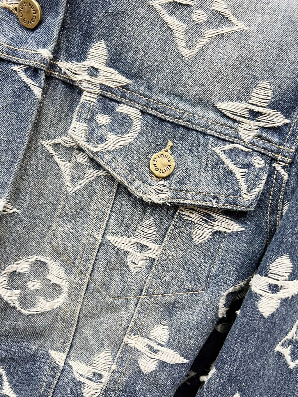 Blue denim jacket chest flap pocket with white monogram and round gold button