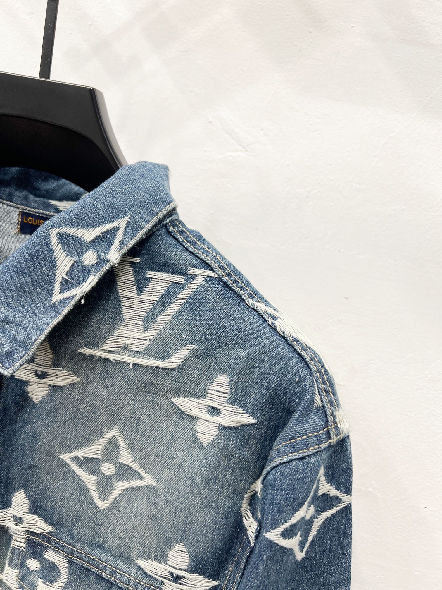 Blue denim jacket shoulder and collar with white monogram pattern