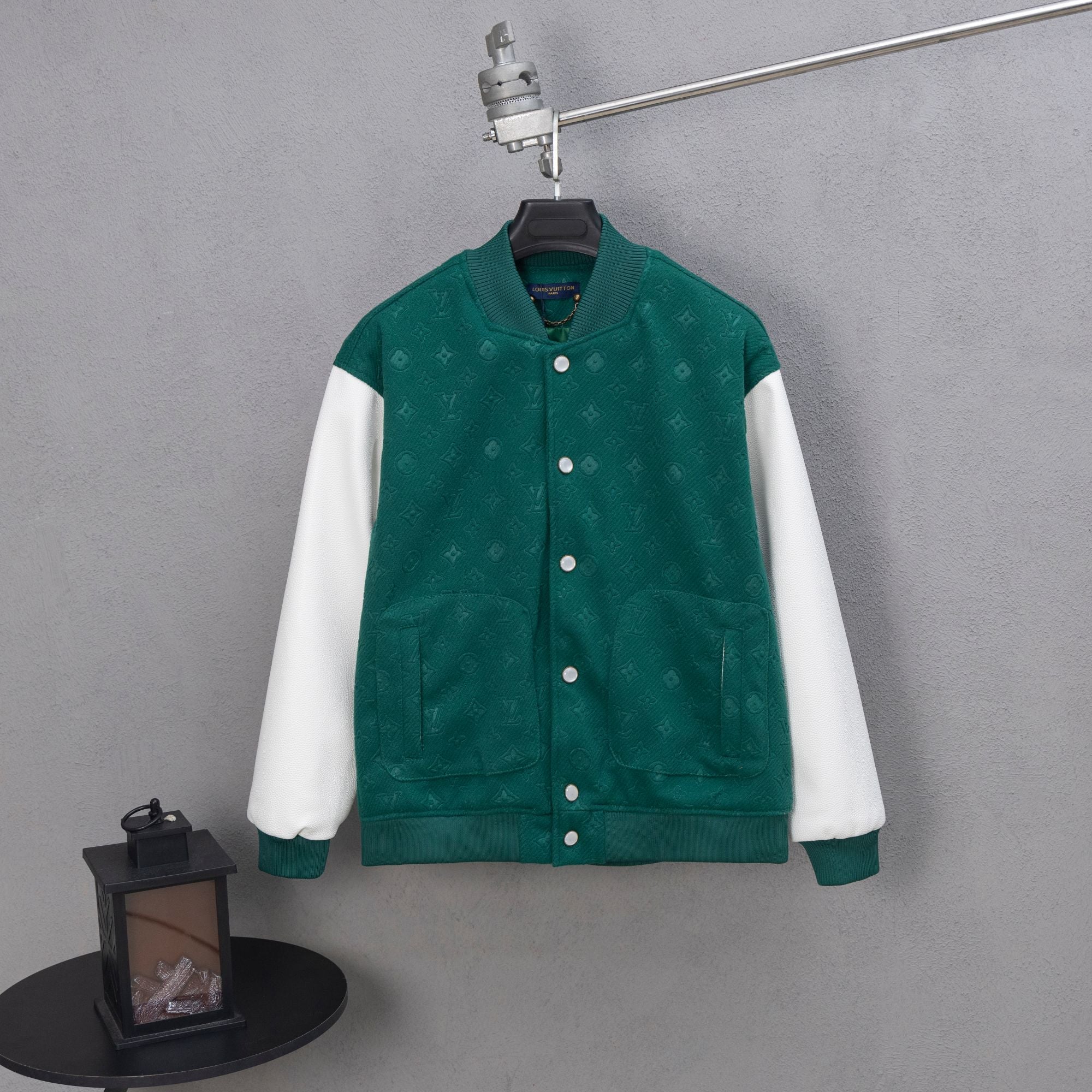 Long-sleeve varsity jacket, dark green with white sleeves and snap button front.
