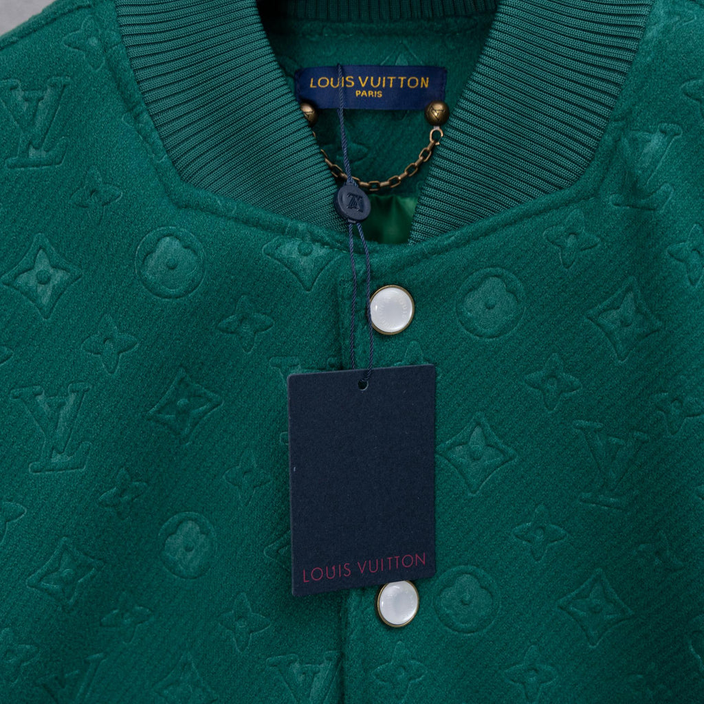 Long-sleeve jacket neckline with Louis Vuitton label, chain detail, and round snap hardware.