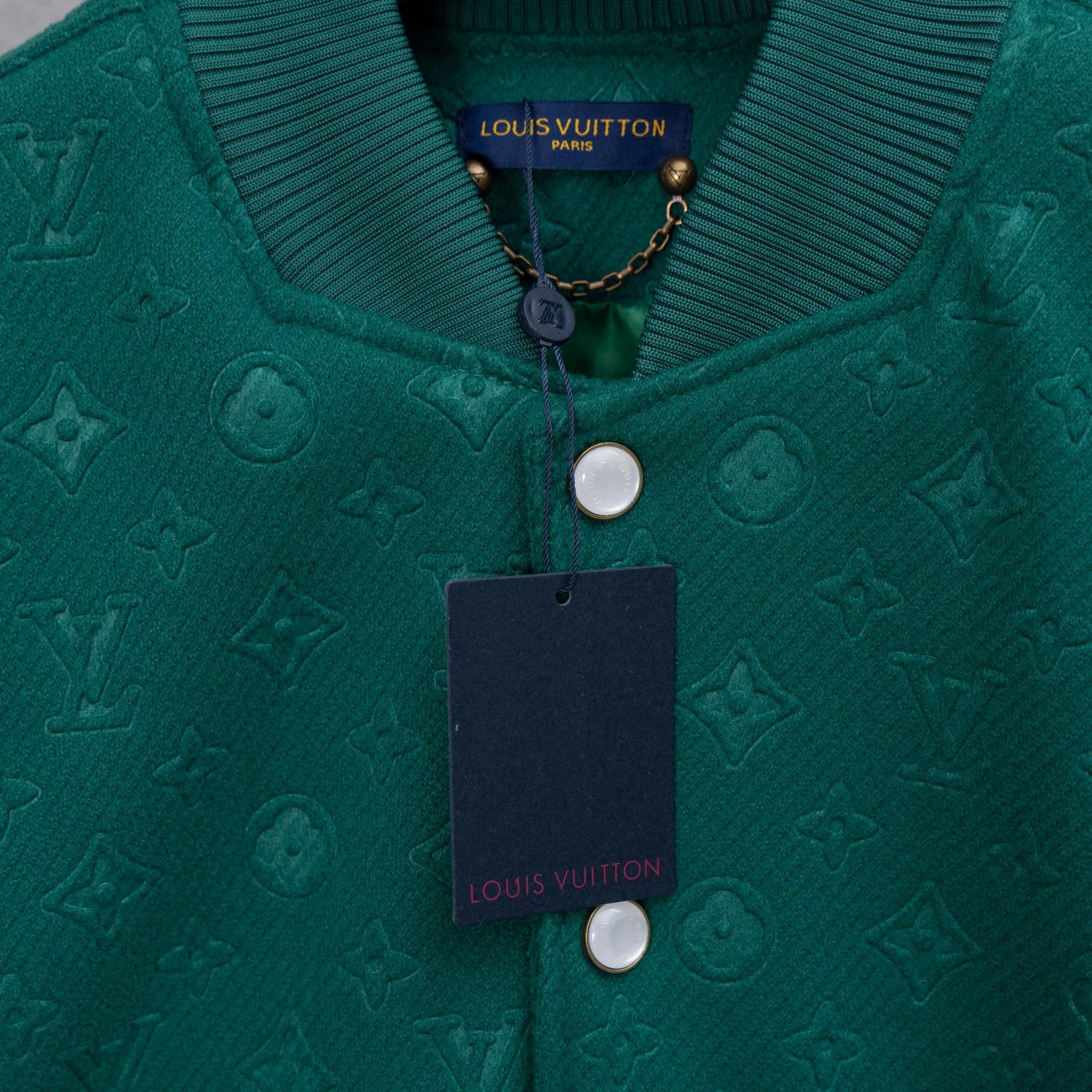 Long-sleeve jacket neckline with Louis Vuitton label, chain detail, and round snap hardware.
