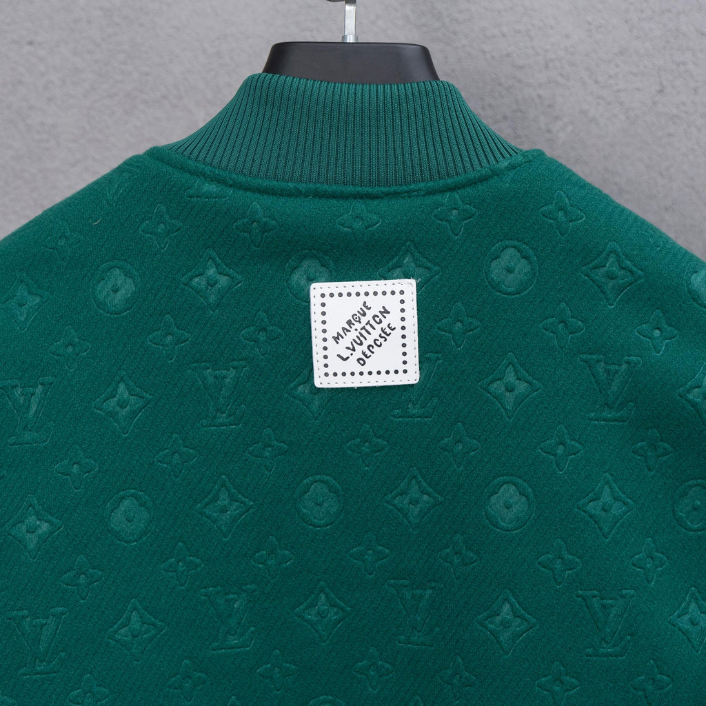 Long-sleeve jacket back, dark green knit with square logo patch at center.