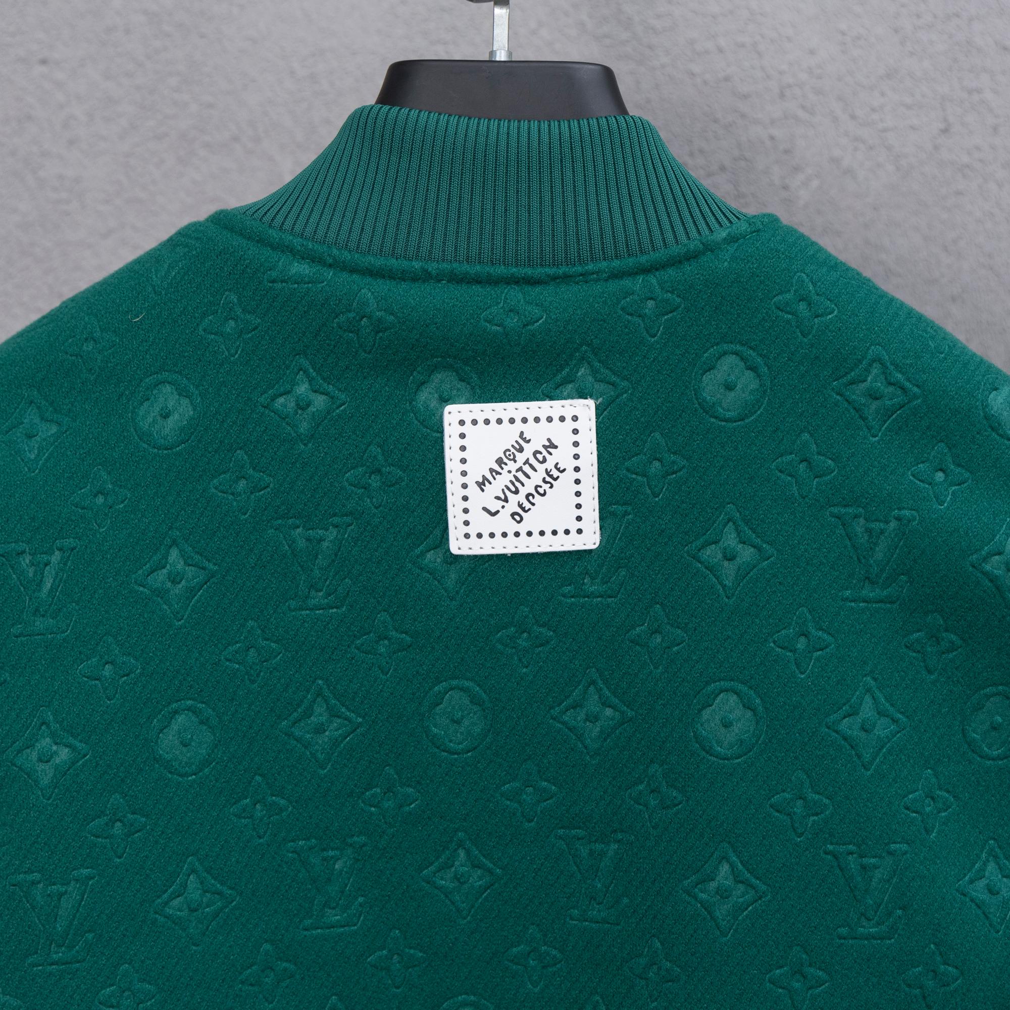 Long-sleeve jacket back, dark green knit with square logo patch at center.