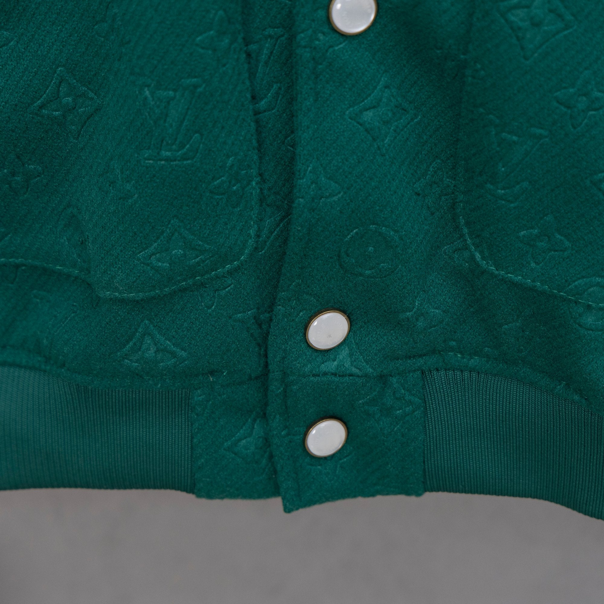 Long-sleeve jacket front, two chest snap buttons and dual side pockets on ribbed trim.