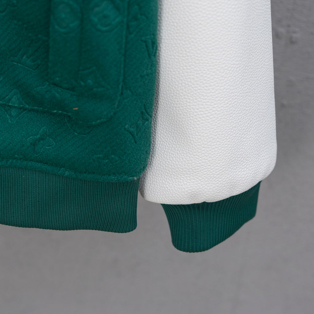 Jacket sleeve hem and white underlayer, ribbed cuff on dark green knit body.