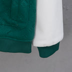 Jacket sleeve hem and white underlayer, ribbed cuff on dark green knit body.