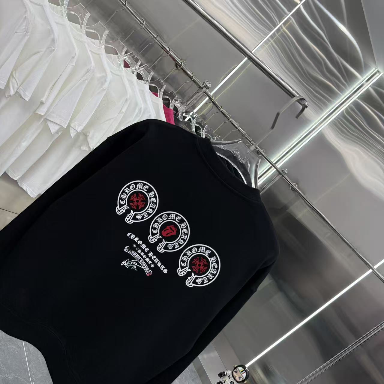Black long-sleeve crewneck sweatshirt with three circular emblem graphics.