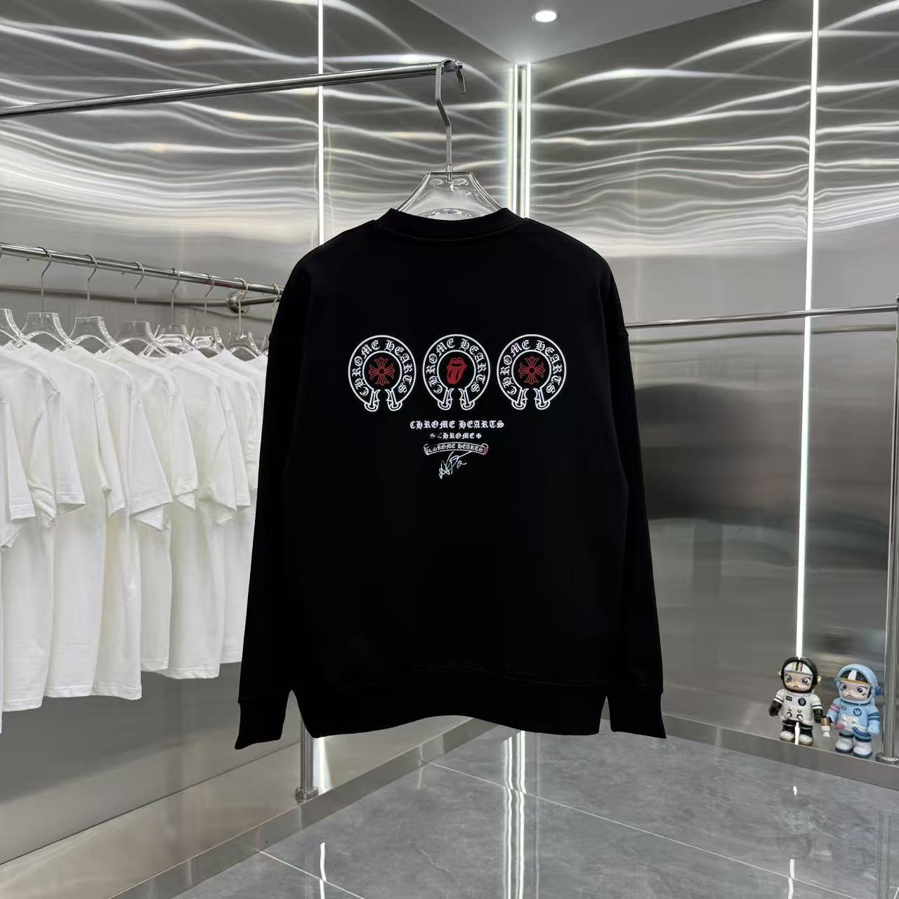Black long-sleeve crewneck sweatshirt with large circular emblem graphic.