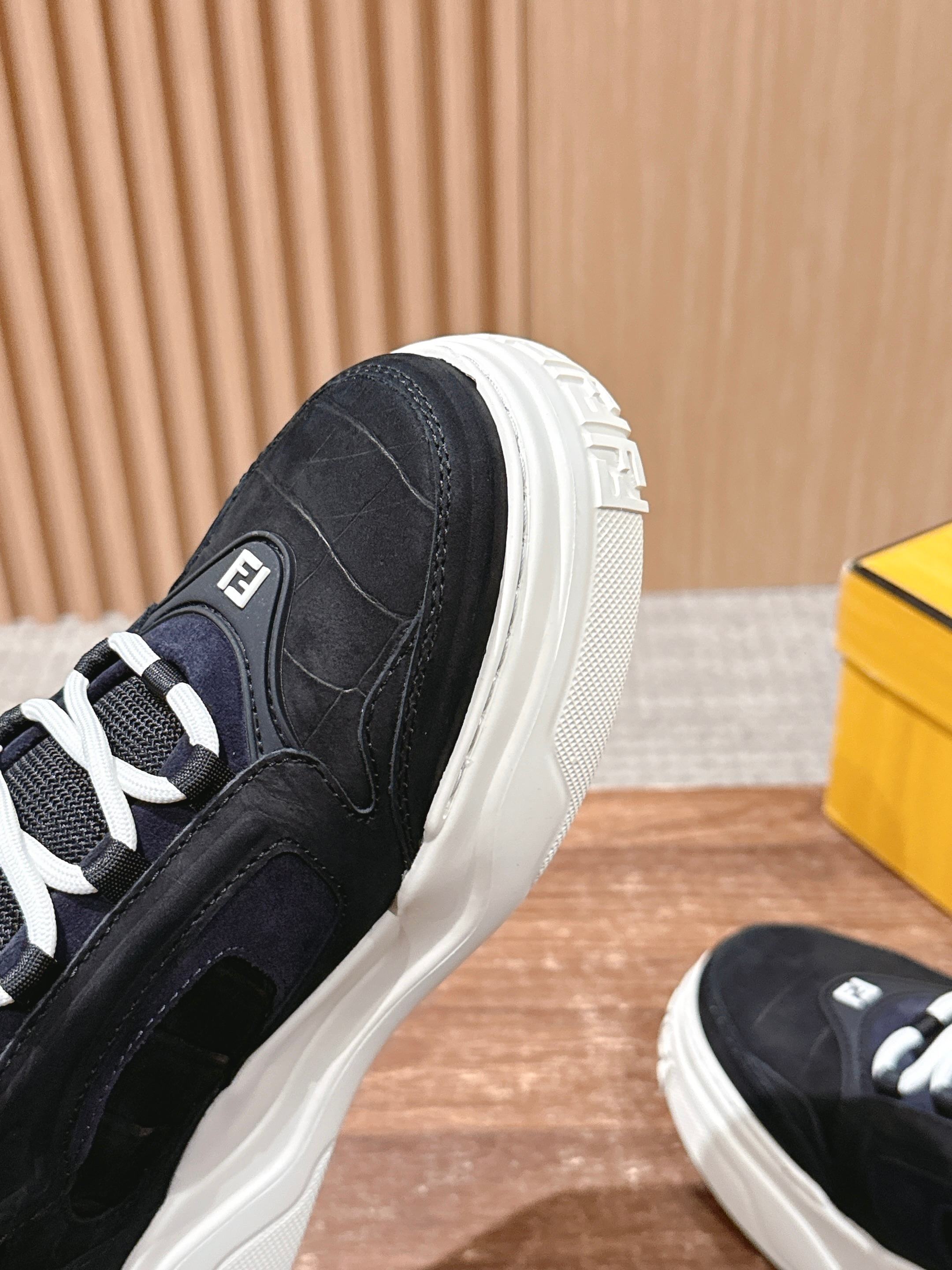 Black Fendi sneaker side view with textured upper and white platform sole