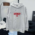 White Givenchy hoodie with red “GIVENCHY PARIS” logo and textured patches across front