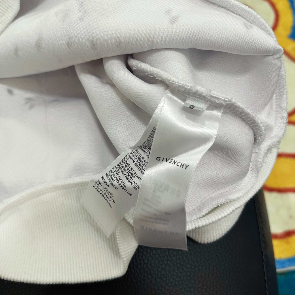 White Givenchy hoodie hood close-up with hanging size label and drawstring