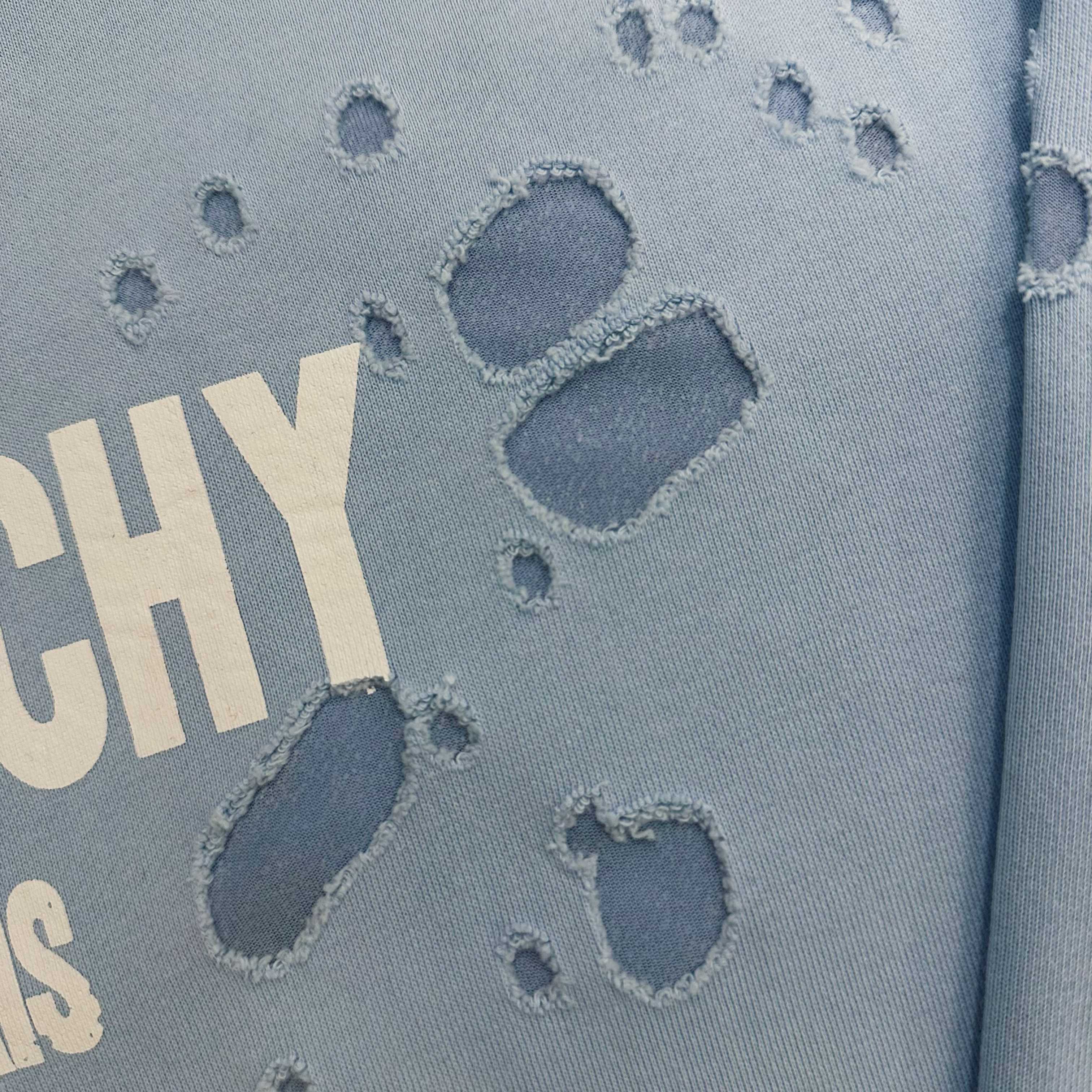 Light blue hoodie fabric close-up with raised paw-print graphic