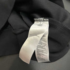 Black hoodie with white care label tag attached at collar