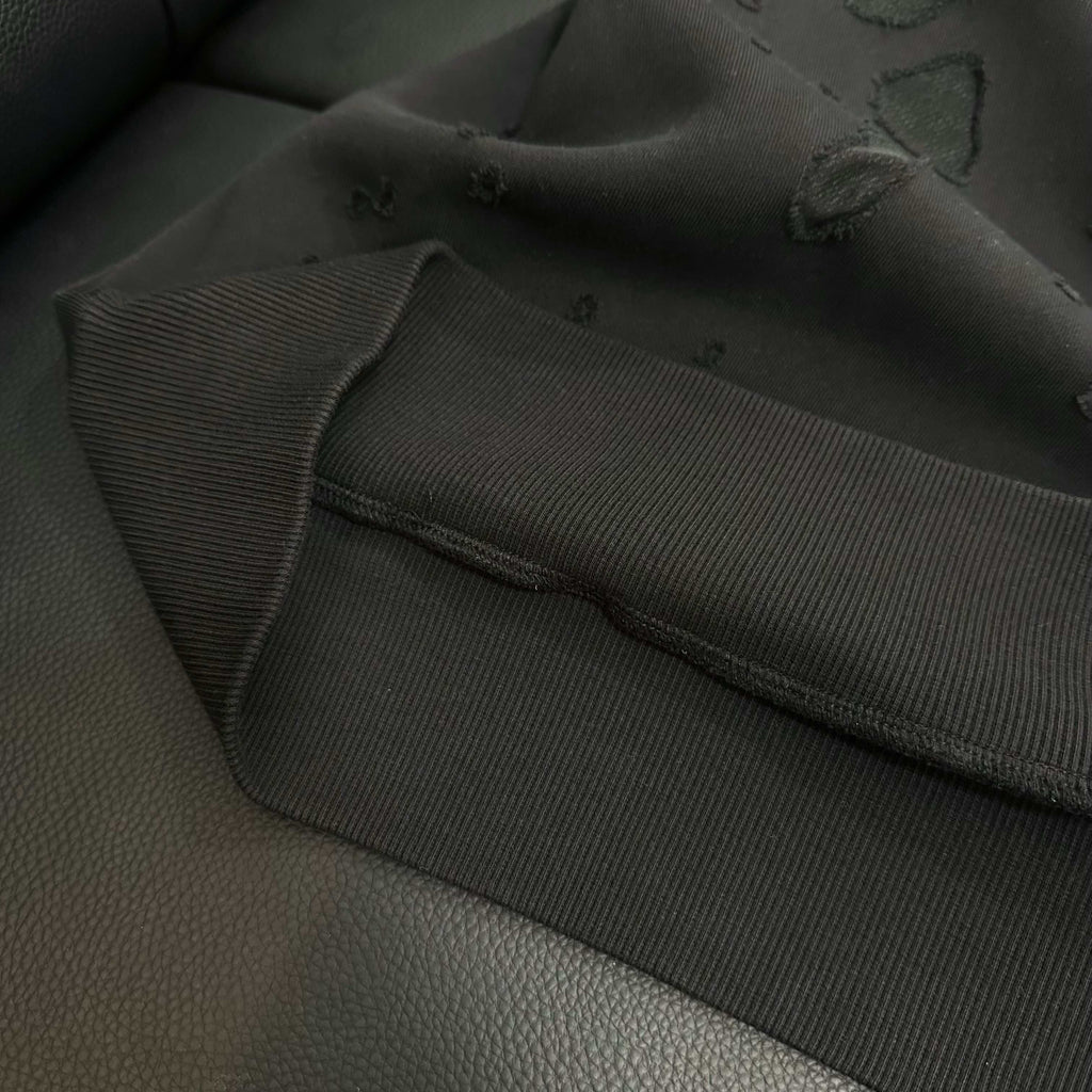 Black hoodie sleeve cuff with ribbed hem and seam detail