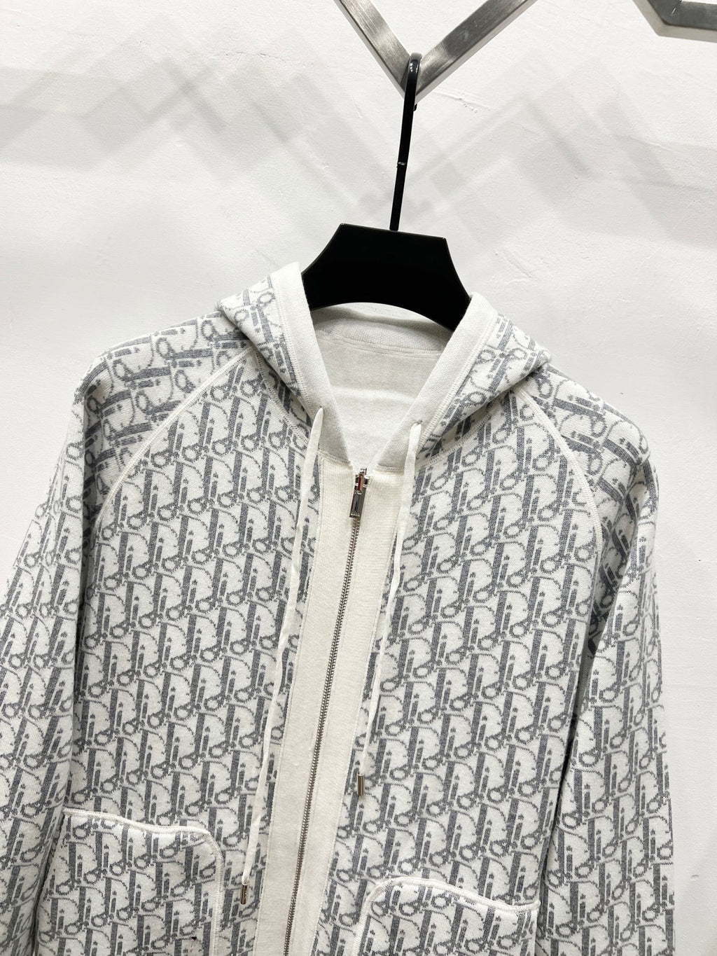 Dior long zip-up hoodie close-up, gray-and-white monogram print with hood and zipper