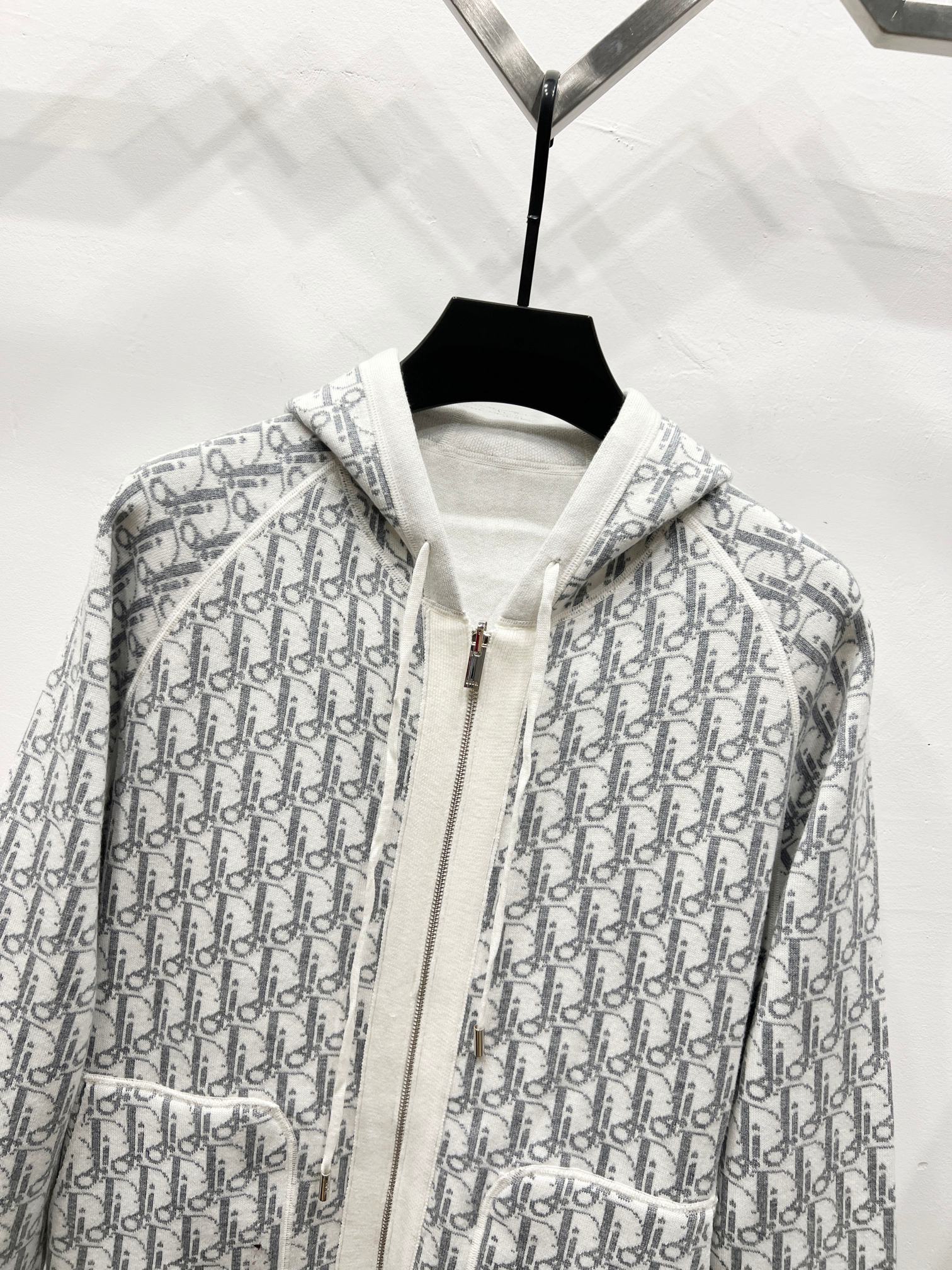 Dior long zip-up hoodie close-up, gray-and-white monogram print with hood and zipper