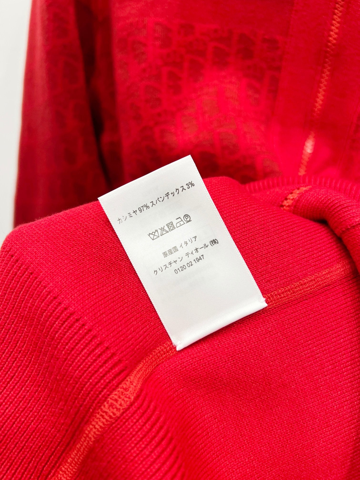 Red hooded sweatshirt inner collar label on ribbed knit cuff near zipper