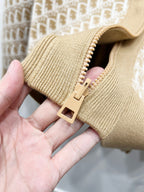 Tan knit hooded sweatshirt sleeve cuff with zipper pull detail