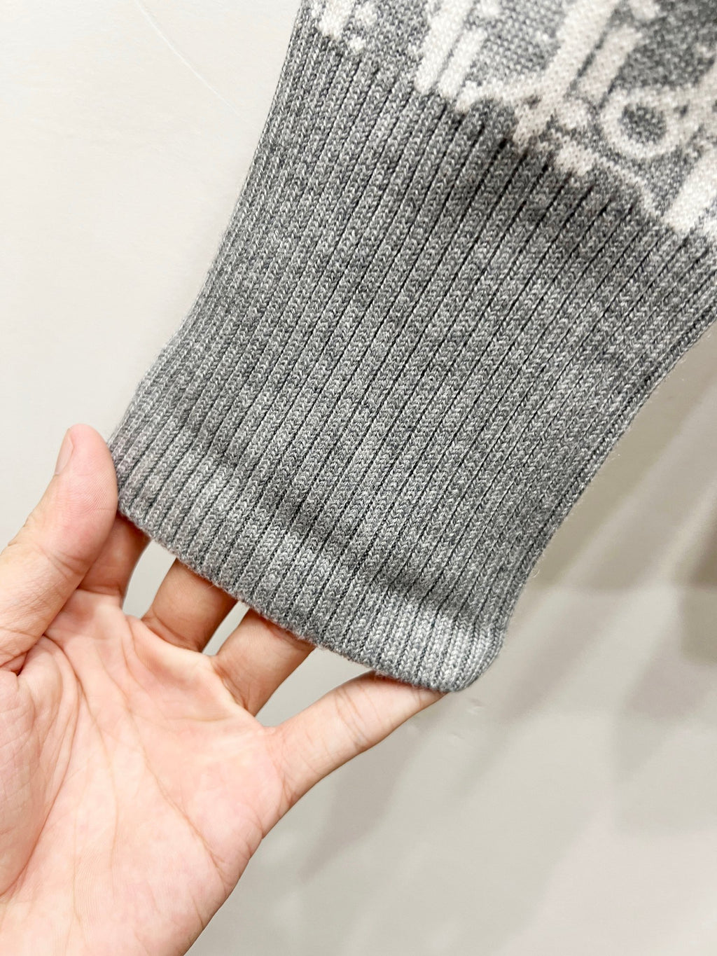 Gray ribbed knit cuff held in hand