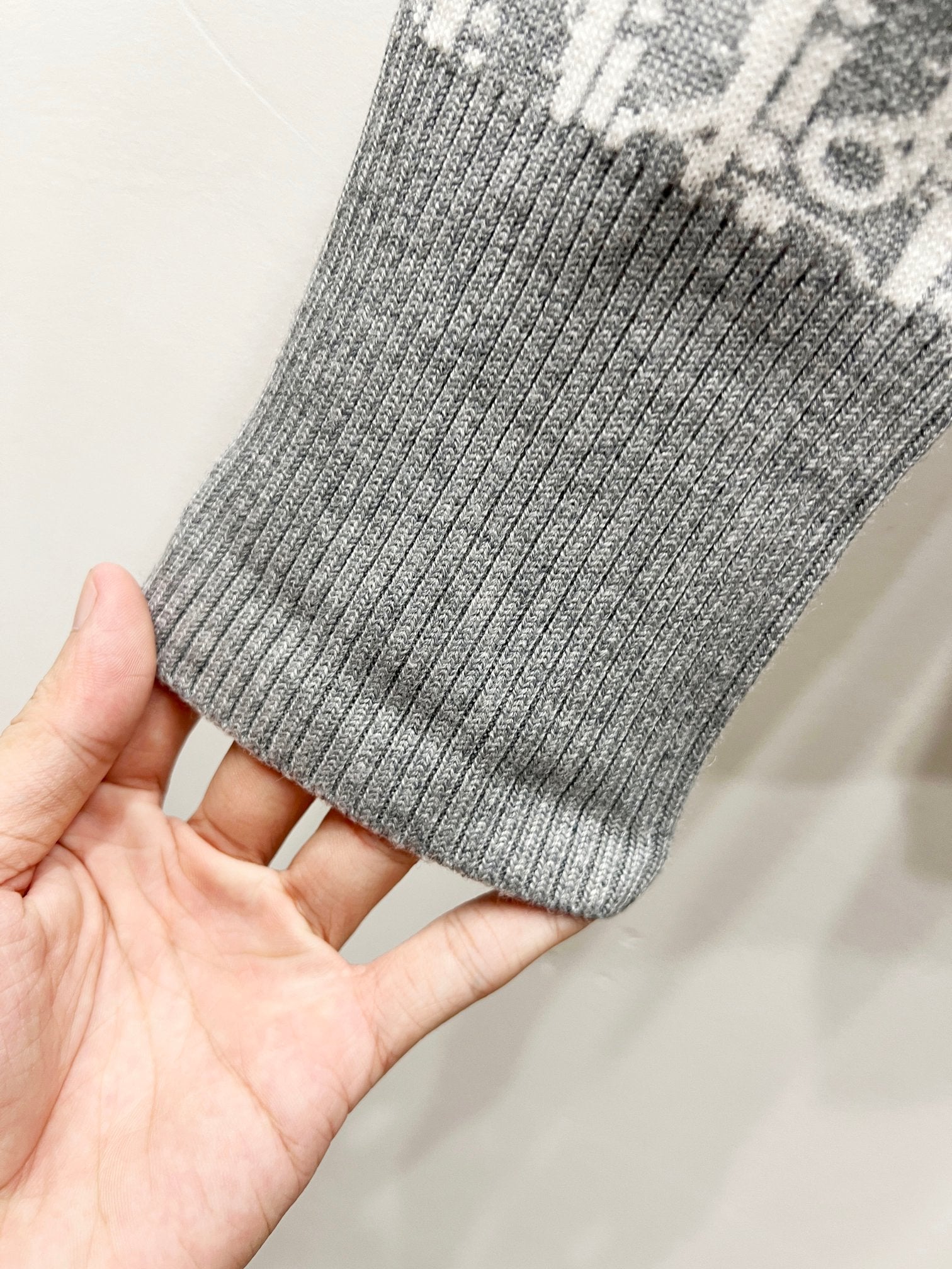 Gray ribbed knit cuff held in hand