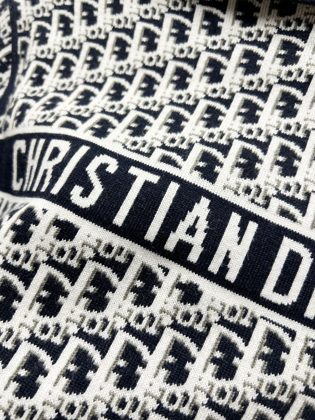 Close-up of navy and white repeating logo knit fabric