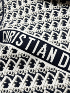 Close-up of navy and white repeating logo knit fabric