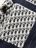 Close-up of navy-trimmed knit fabric with repeating logo pattern