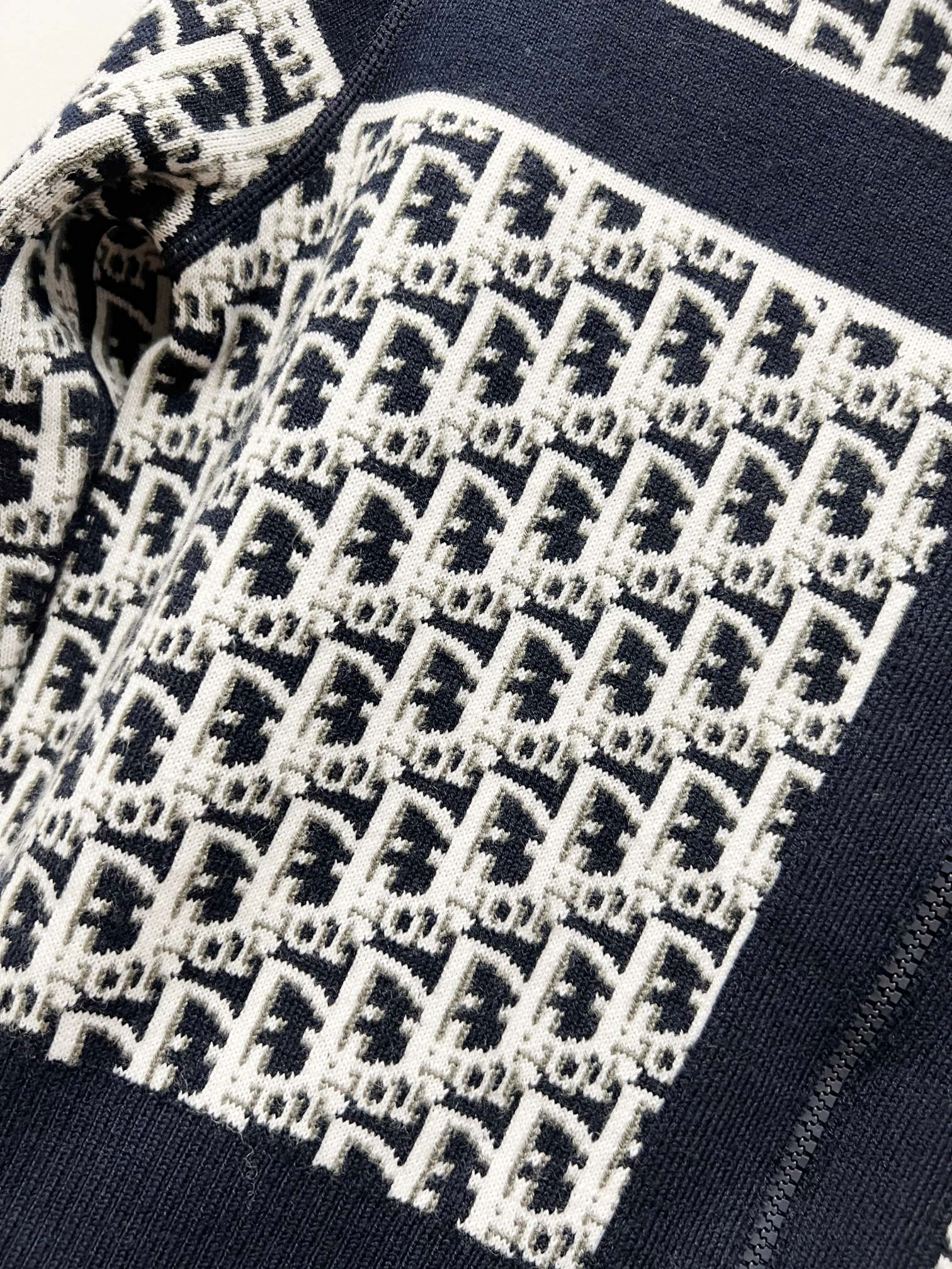 Close-up of navy-trimmed knit fabric with repeating logo pattern