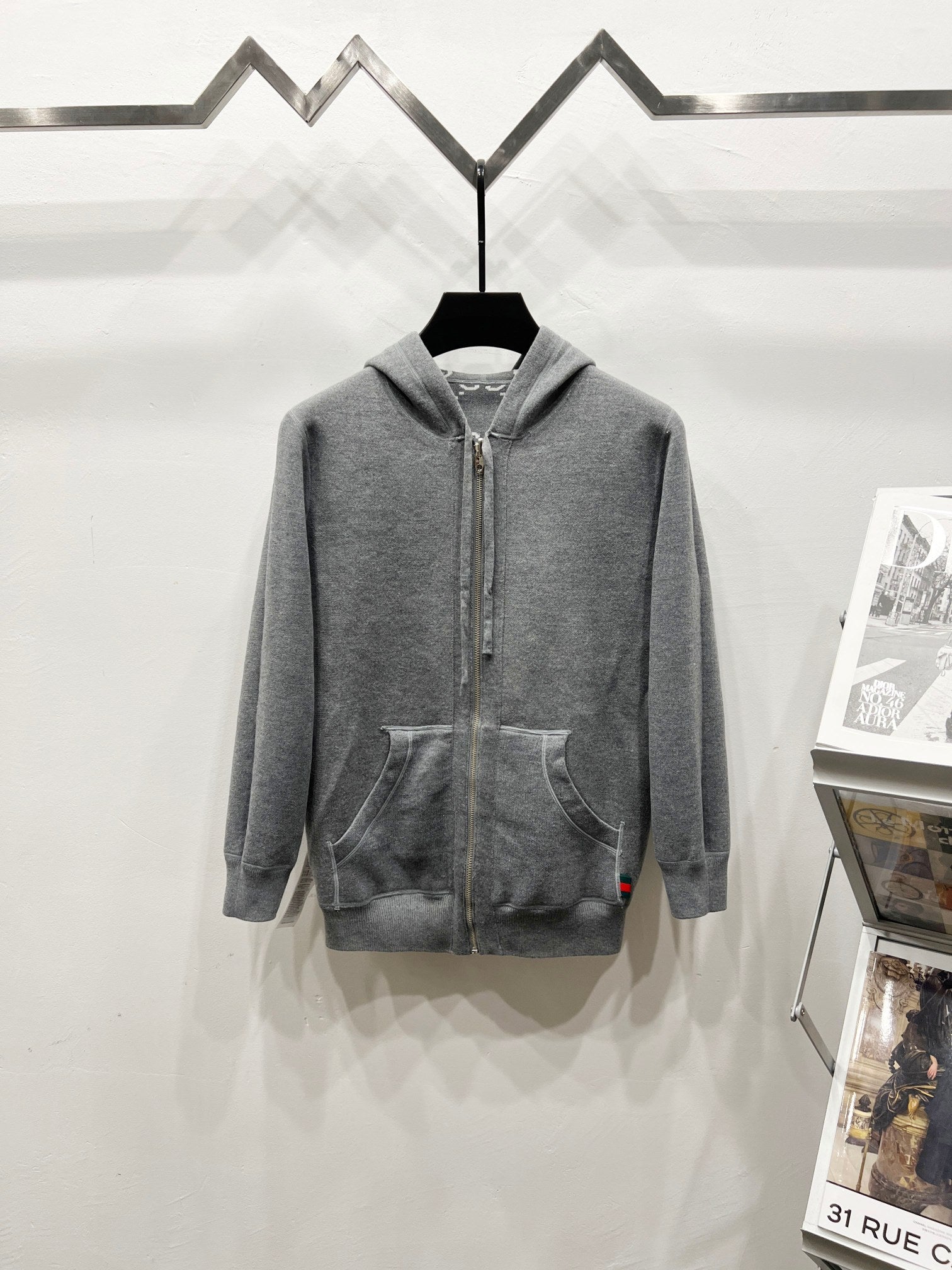 Grey zip-up hoodie with drawstring hood and side pockets, full monogram pattern